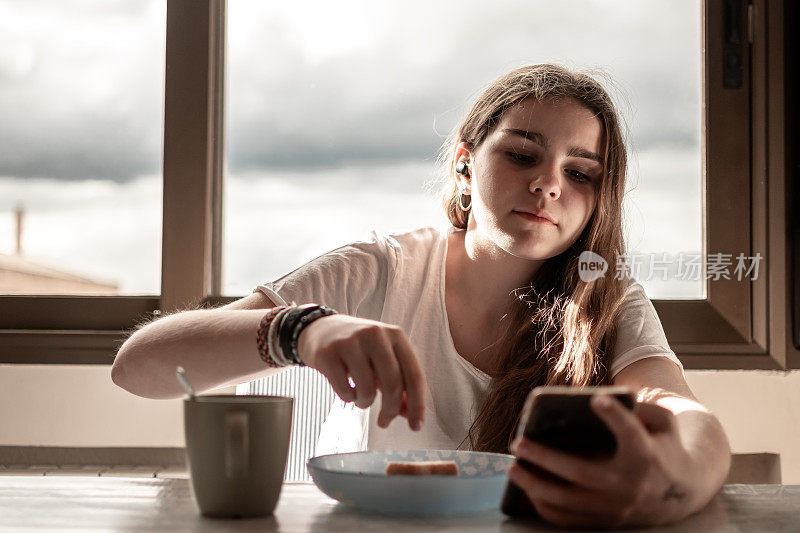 青少年一边看手机一边吃零食