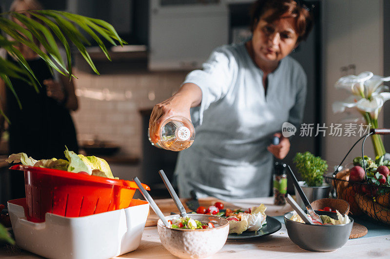 一个女人倒色拉油的特写