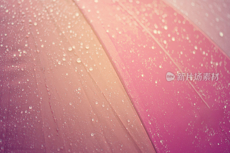 特写雨伞在秋雨霏霏的日子里用彩虹的色彩，模糊对焦