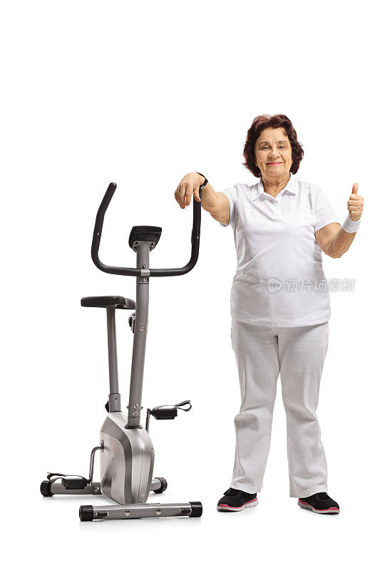一位老妇人靠在健身自行车上，竖起大拇指