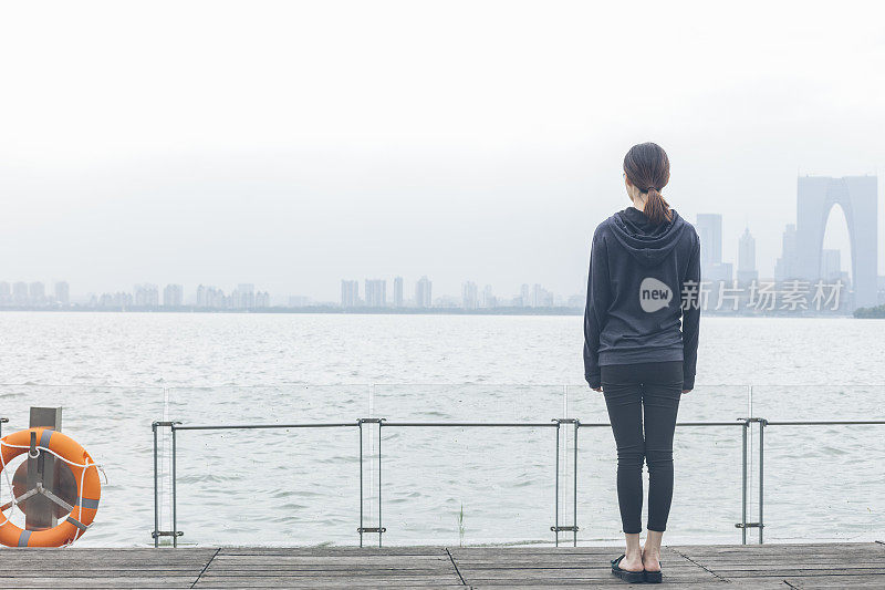 后视图的女人站在湖边看美丽的风景