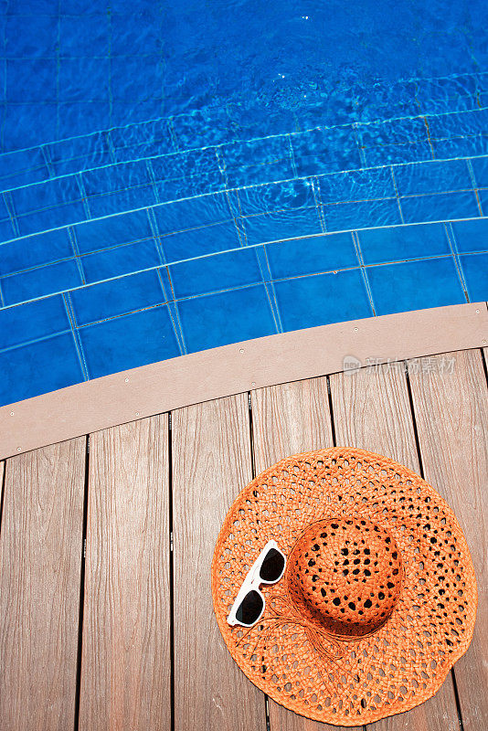 游泳池旁的太阳帽和太阳镜——夏日度假概念