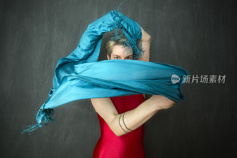 穿着红色紧身衣挥舞着蓝色围巾的年轻女子。