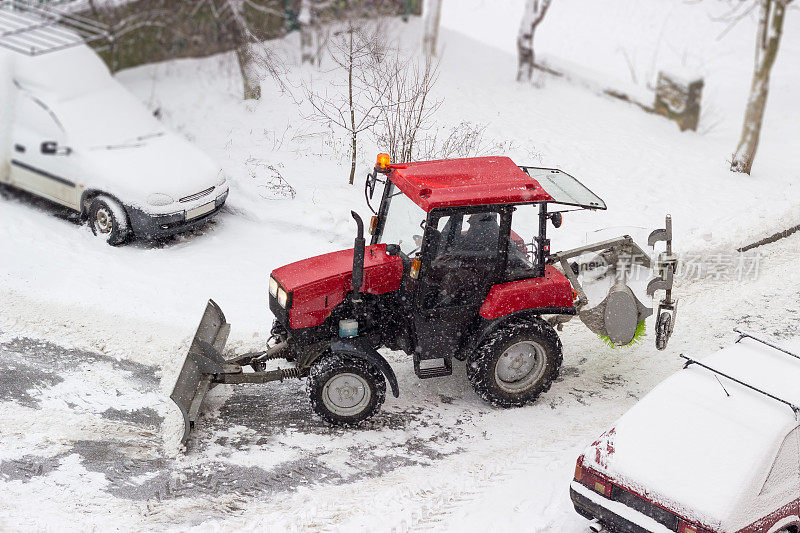 小型拖拉机扫雪机在下雪时停放在院子里