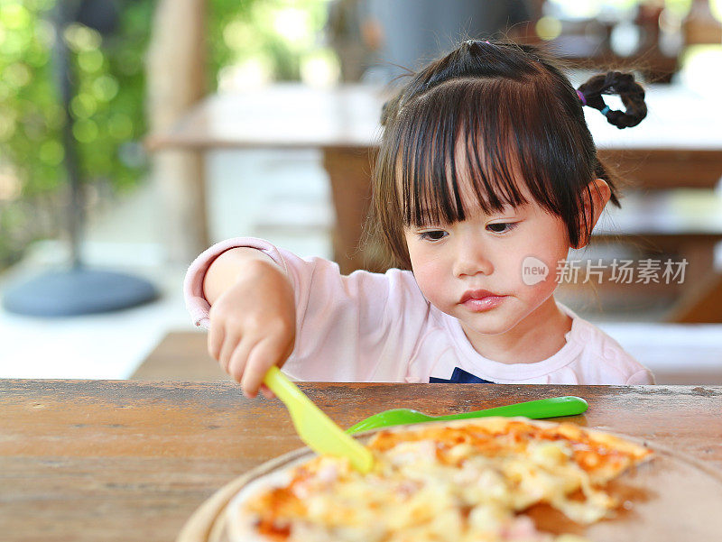 小女孩喜欢吃披萨。