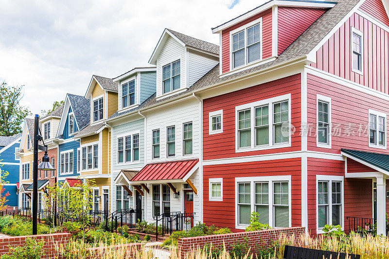 一排排五颜六色的、红的、黄的、蓝的、白的、绿的住宅联排别墅，在夏天有砖砌的庭院花园