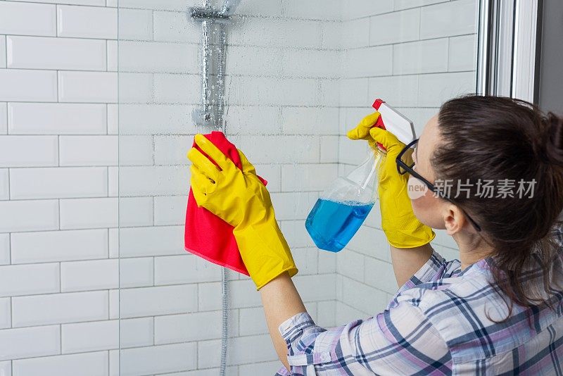 家务和家庭生活方式。一个女人在用抹布清洗浴缸