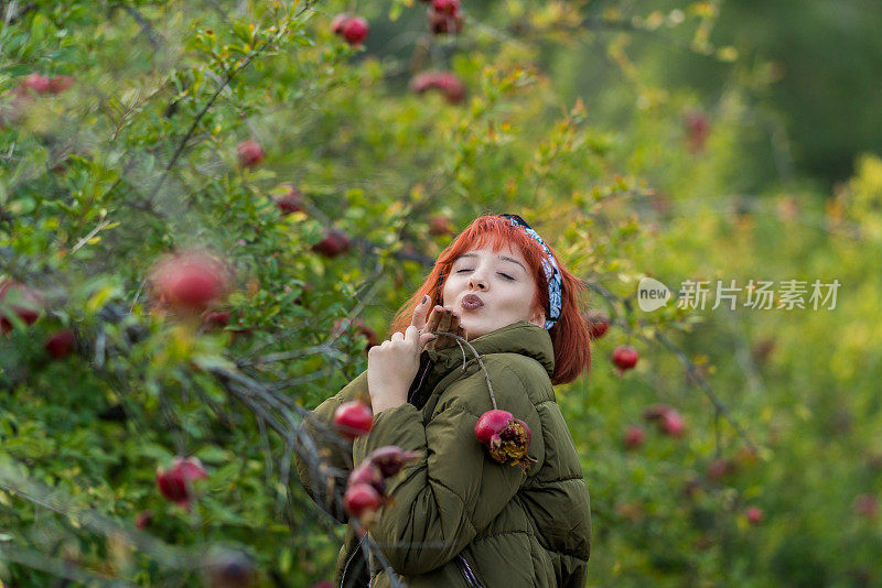 年轻美丽的姑娘和石榴树