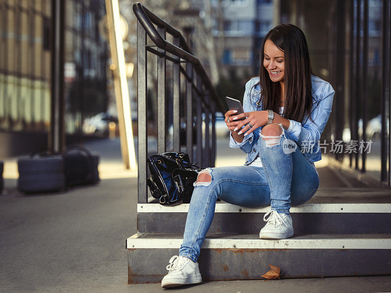 年轻女子在智能手机上发短信