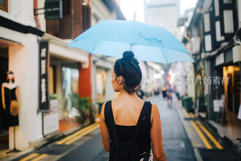 旅女在雨中探索新加坡的小巷子