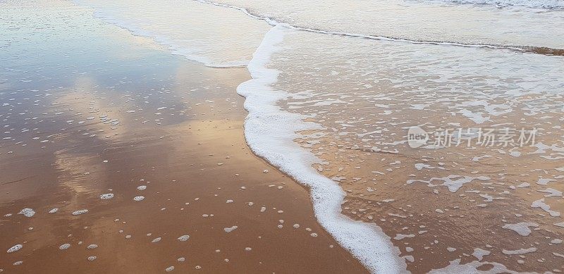 泡沫状的白色海浪拍打着海滩