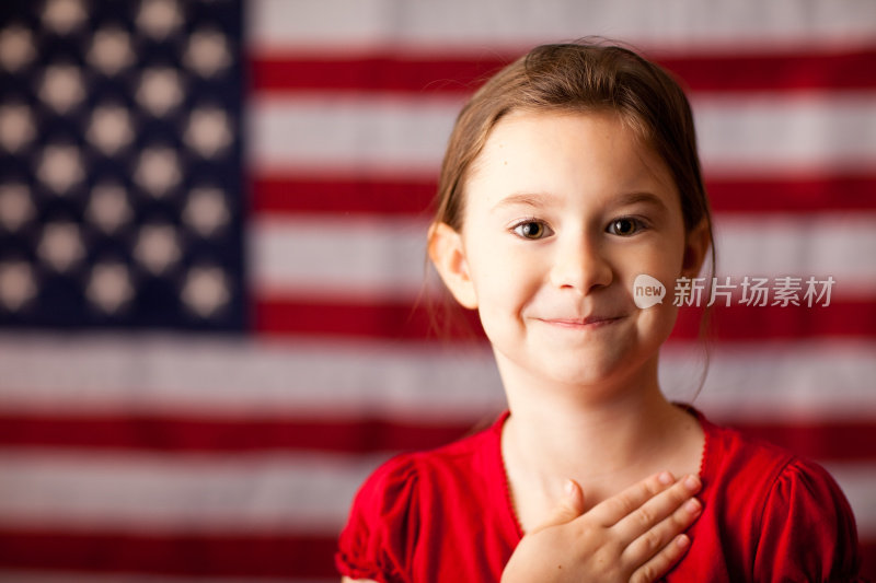 美国国旗上的快乐少女手放在心上
