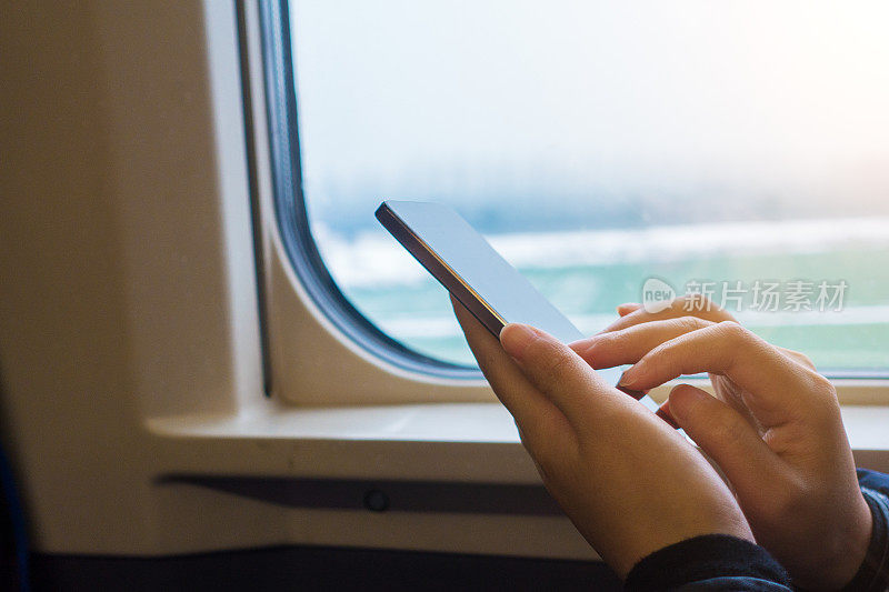 一名女子在火车上使用智能手机