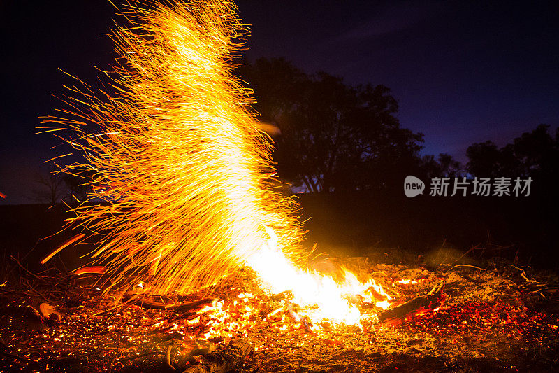 一个明亮的橙色火柱从篝火中爆炸出来