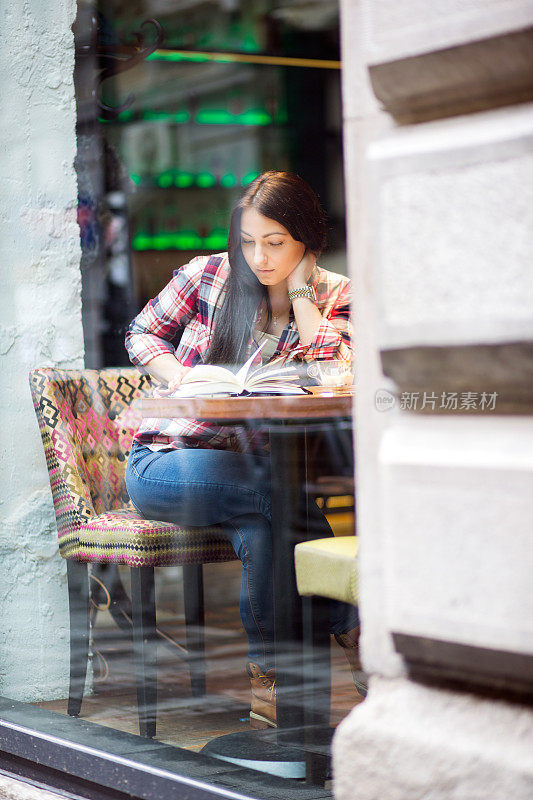 女学生在咖啡馆做作业，喝咖啡。