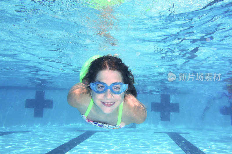 微笑的女孩在水下游泳