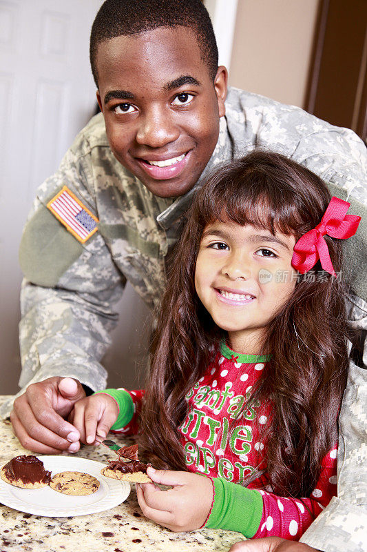 快乐的小女孩在和她的军人亲戚做饼干