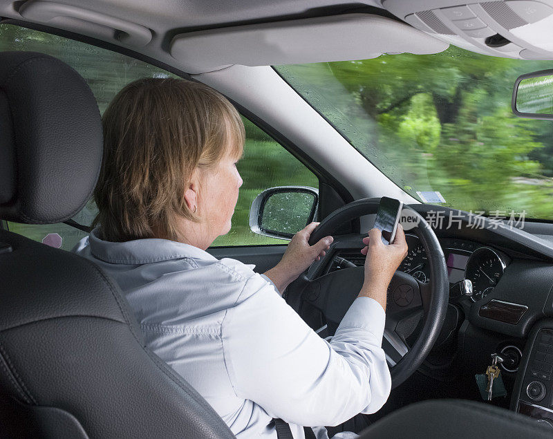 成熟女人开车时发短信。