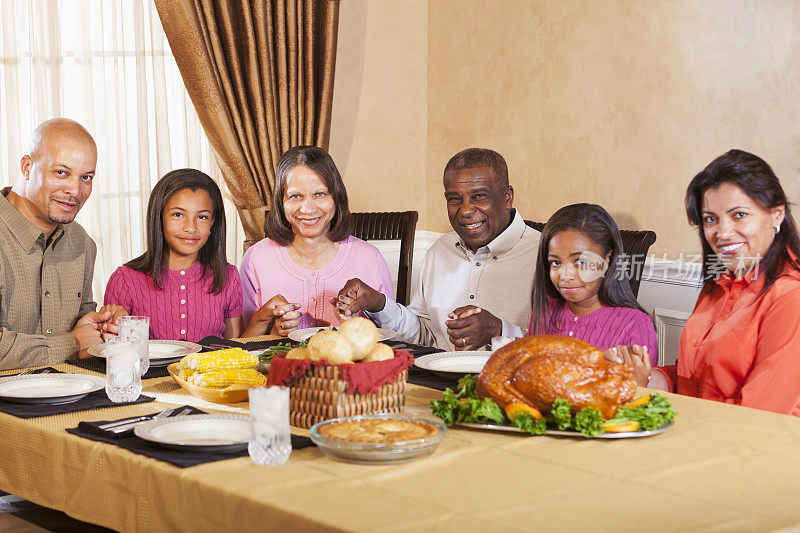 几代非裔美国人家庭在节日晚餐前祷告