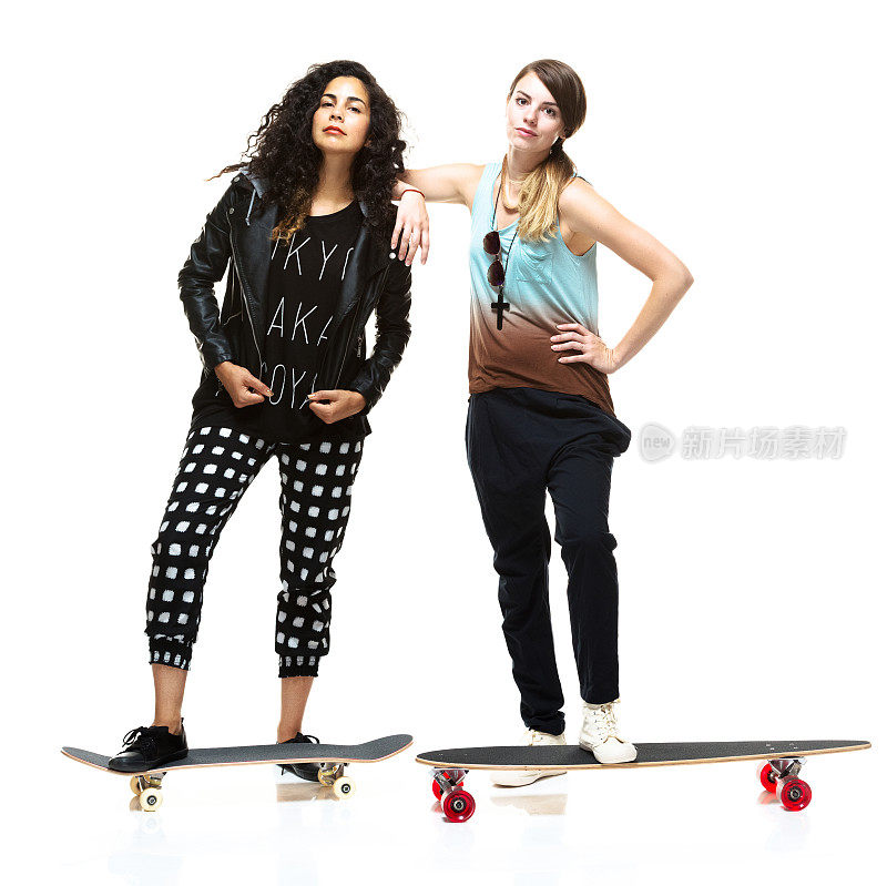 两个小女孩拿着滑板站在那里