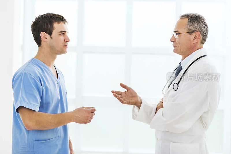 一个成熟的医生在和他的同事交谈。