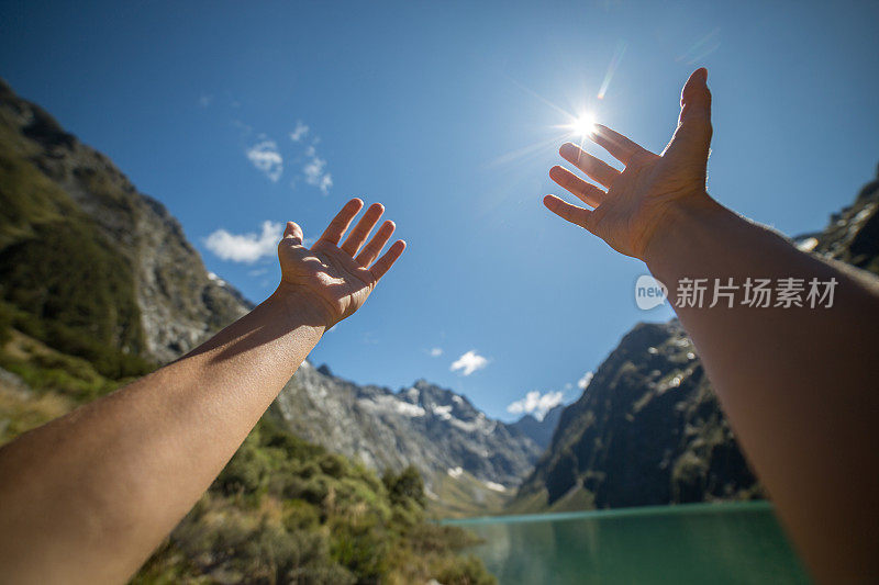 个人视角的女人的双臂伸向山湖