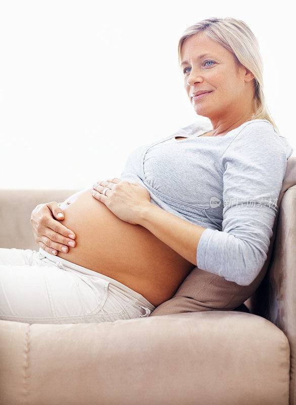 成熟的怀孕女性抱着她的肚子