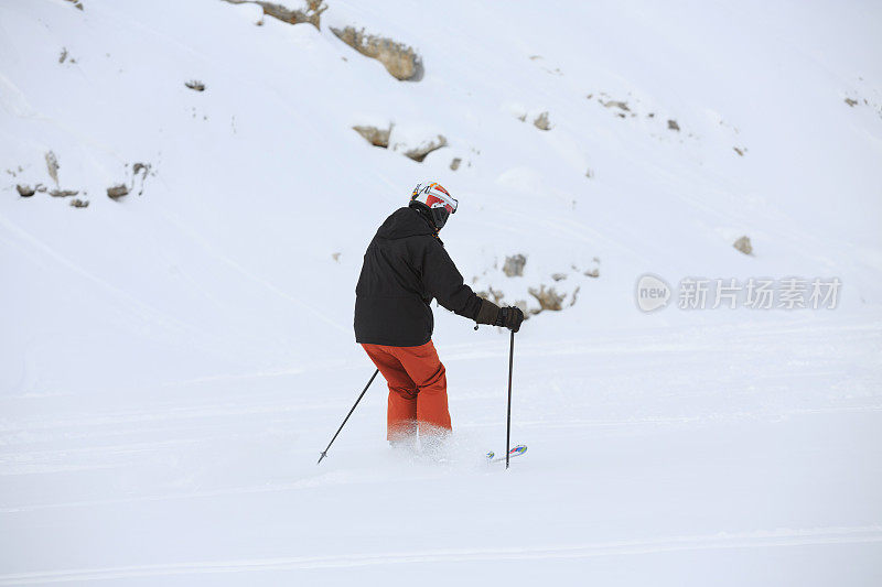 后视图男人在乡间滑雪，雪上有粉