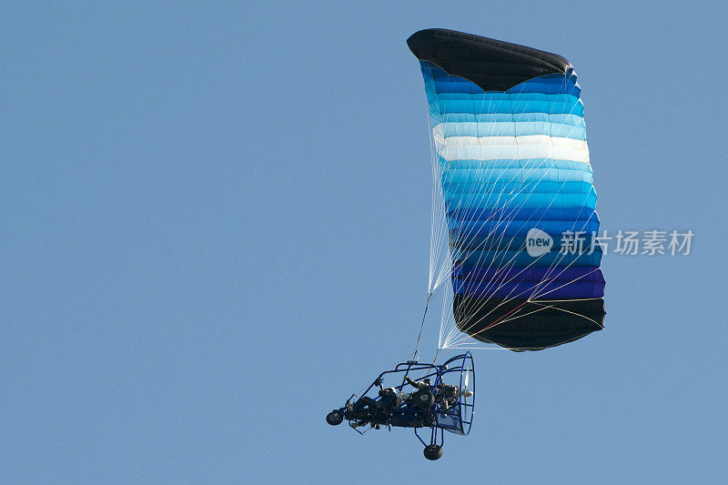 动力降落伞在晴朗的蓝天中飞行