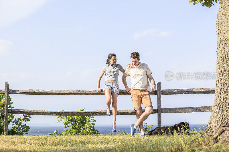 青年男子，少女和黑狗在户外放松