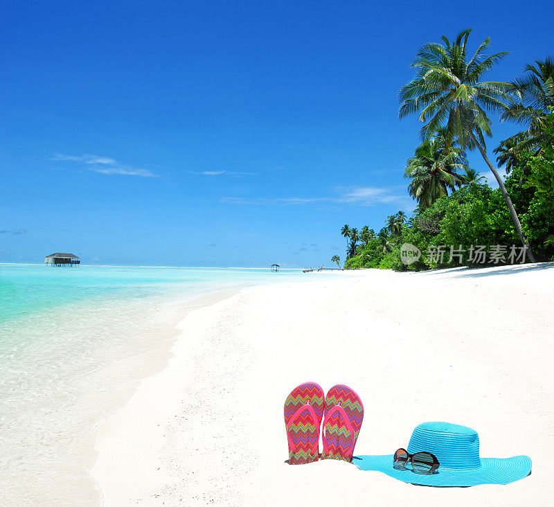 热带海滩上的太阳帽、太阳镜和人字拖
