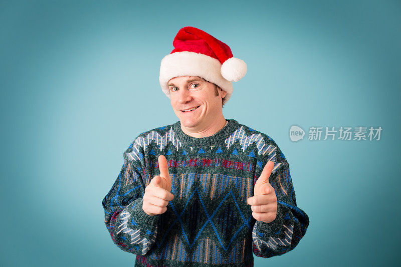 戴着圣诞帽和丑陋毛衣的男人看起来很自信