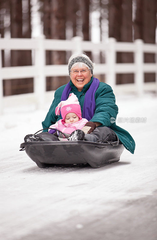 奶奶和孙女在冬天玩雪橇