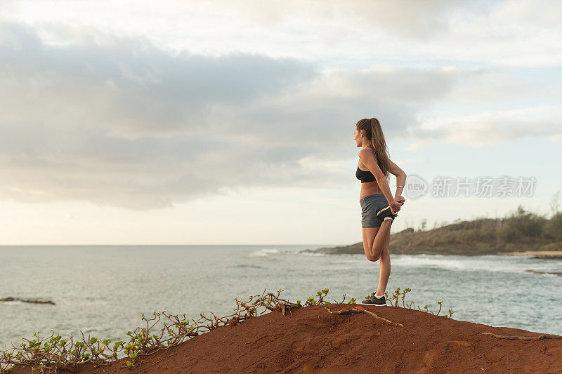 年轻的欧亚混血女子在夏威夷海岸线跑步后休息