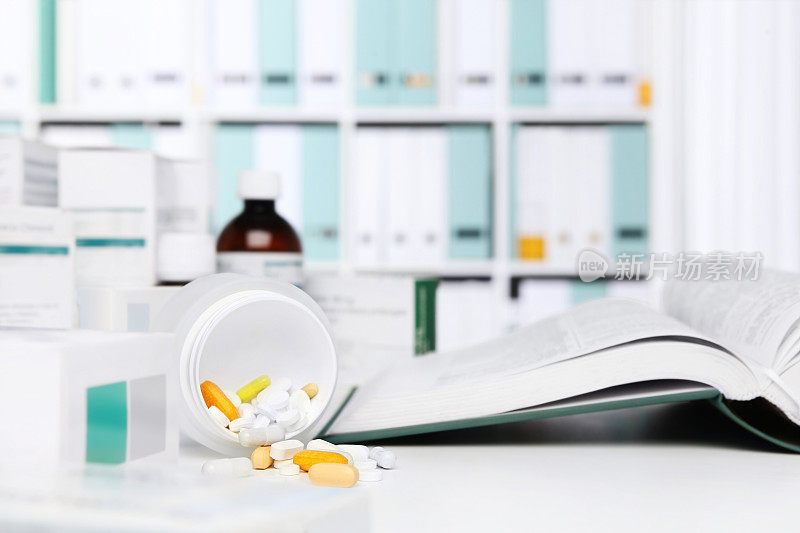 药瓶药丸和胶囊放在桌子上，医药书籍，药品和药片盒在背景