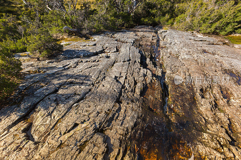 澳大利亚塔斯马尼亚岛摇篮山里拉湖的火山玄武岩中流淌着天然的水流