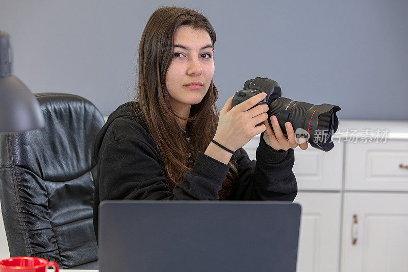 专业摄影师在办公室的概念。桌上的数码相机、镜头和笔记本电脑。摄影师工作空间的概念