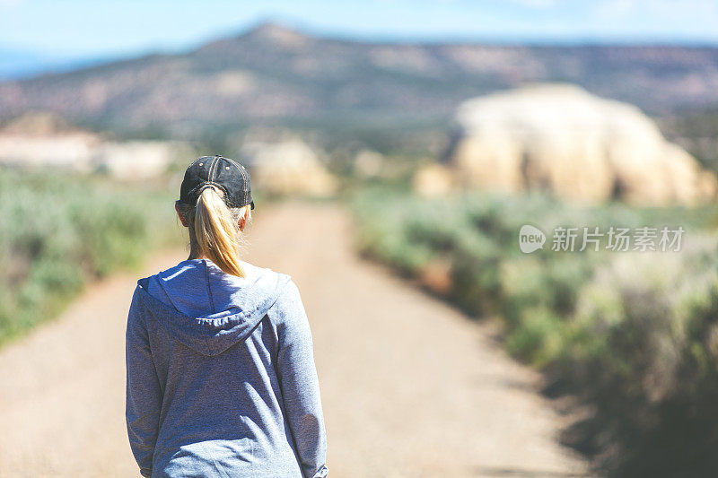 活跃美丽的成熟的成年女性户外在一个土路远足在西部科罗拉多