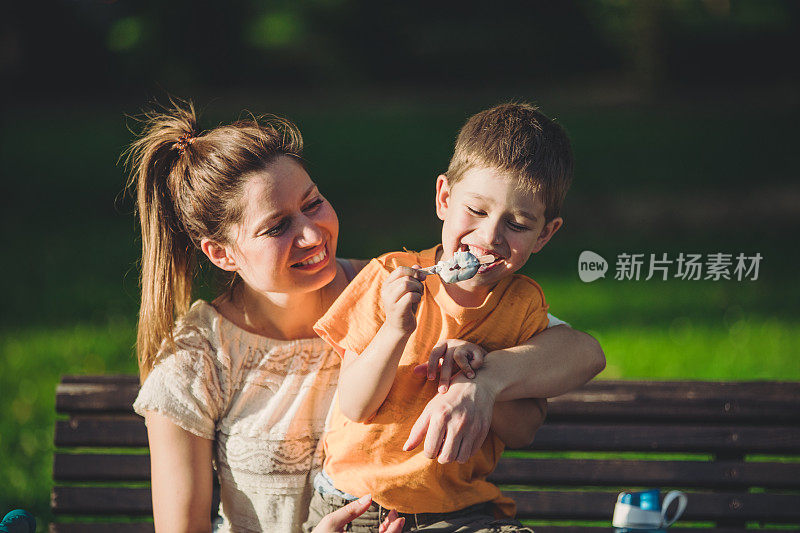 母亲和她的儿子有冰淇淋和拥抱的乐趣