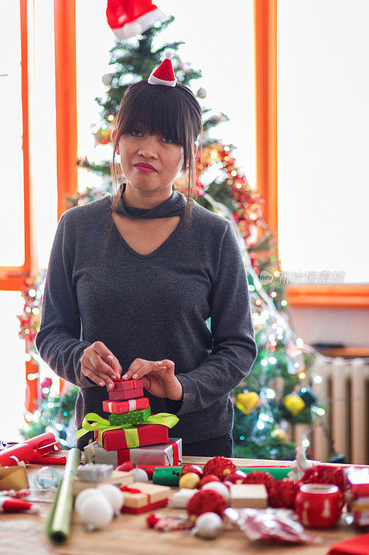 年轻的亚洲妇女包装圣诞礼物