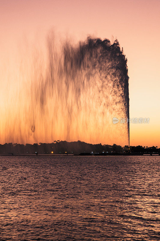 在沙特阿拉伯吉达的南滨海大道上，可以看到世界上最高的法赫德国王喷泉，背景是美丽的日落