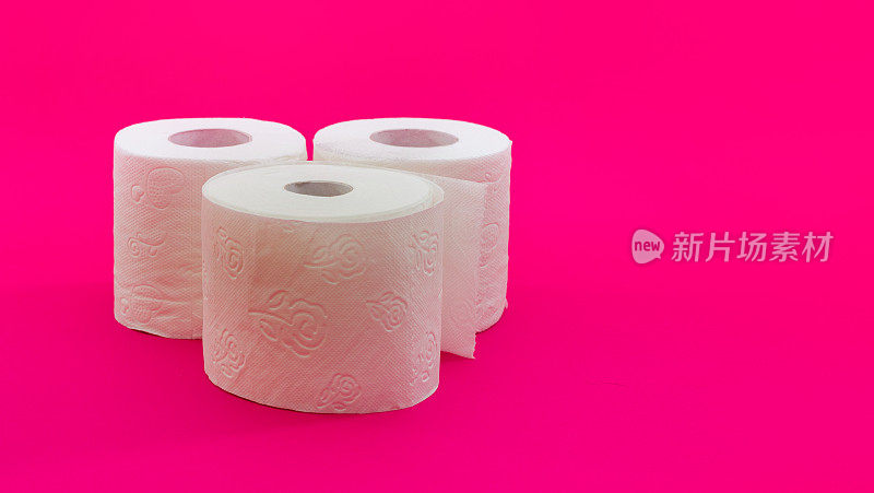 白色卷筒卫生纸在淡粉色的背景上