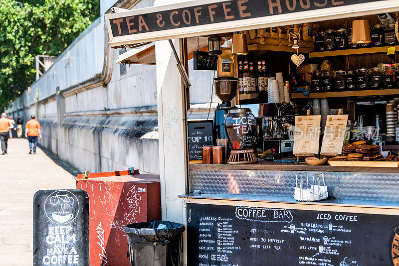 早上，人们在泰晤士河河畔的咖啡馆里喝着咖啡或茶