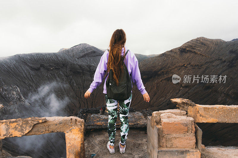 女人背包客在印度尼西亚旅行，享受Bromo火山喷发的景色