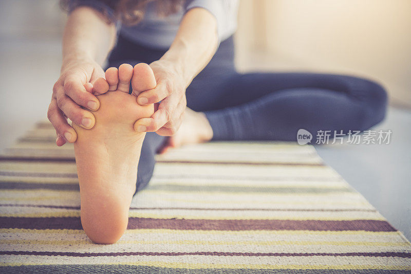 女人在家里做瑜伽近距离的脚，体现和意识通过运动