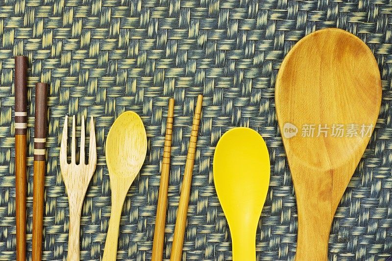 筷子，勺子和器皿-编织织物背景。