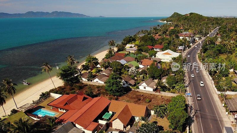 在海边的道路和房屋。在泰国阳光明媚的日子里，苏梅岛的主要道路和海岸别墅被无人机拍摄。邦坡热带风情海滩。