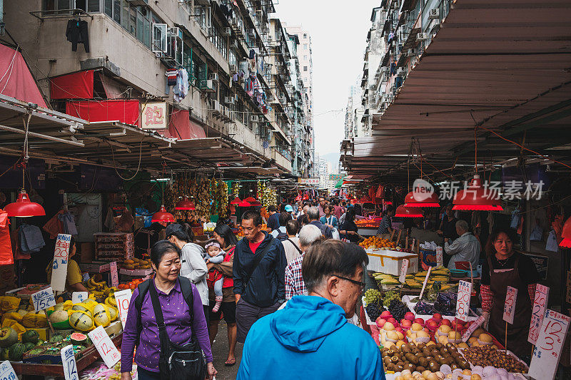 人们在香港的街头食品市场上购买蔬菜和水果