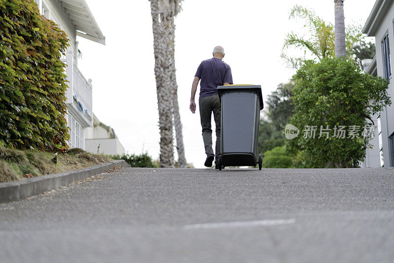 有垃圾或回收箱的老人