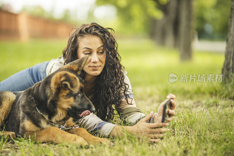 一个女人和她的狗在她的手机自拍